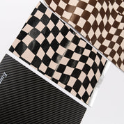 Close-up of the carbon fiber weave and Essential Hair logo with check foils on the boards