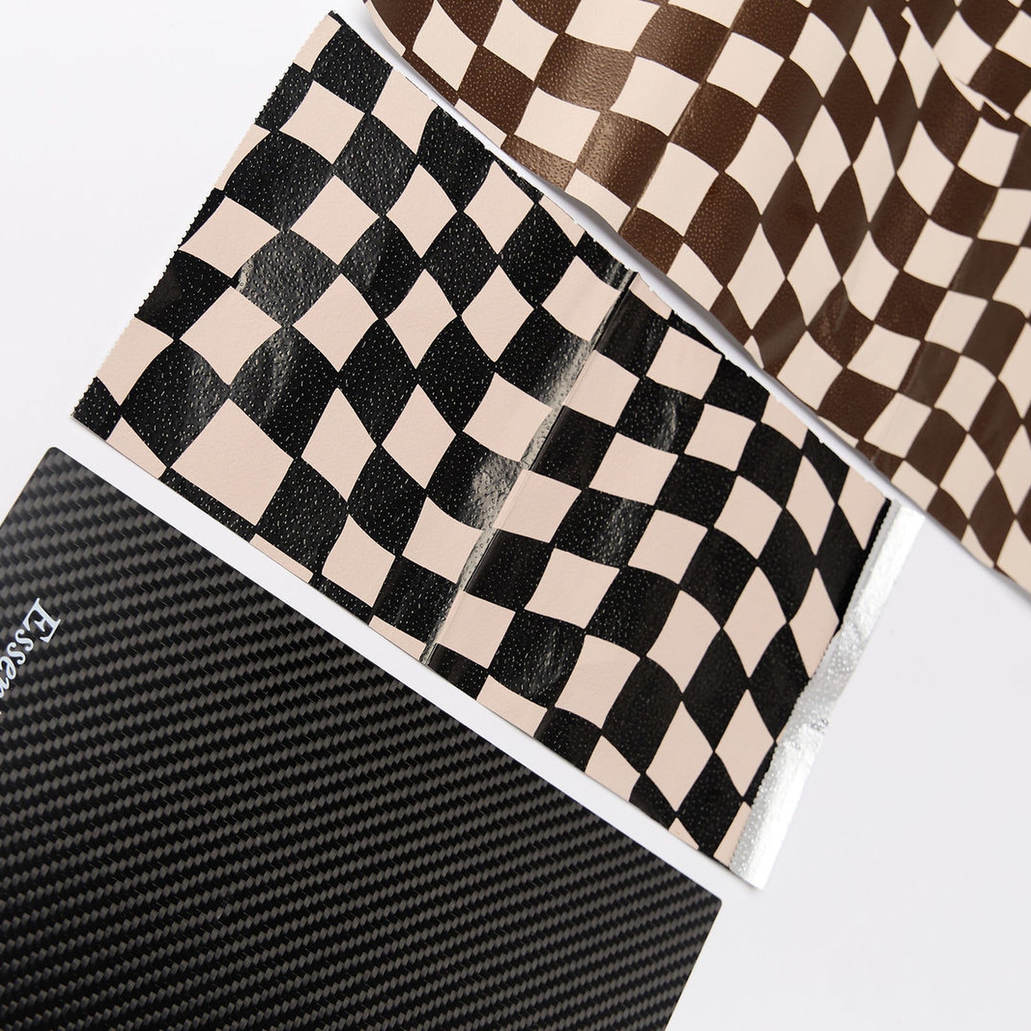Close-up of the carbon fiber weave and Essential Hair logo with check foils on the boards